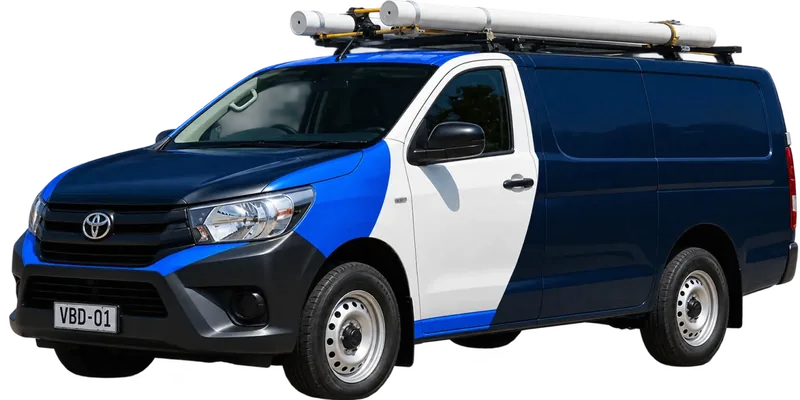 A licensed Mosman plumbing van loaded with pipe on the roof rack
